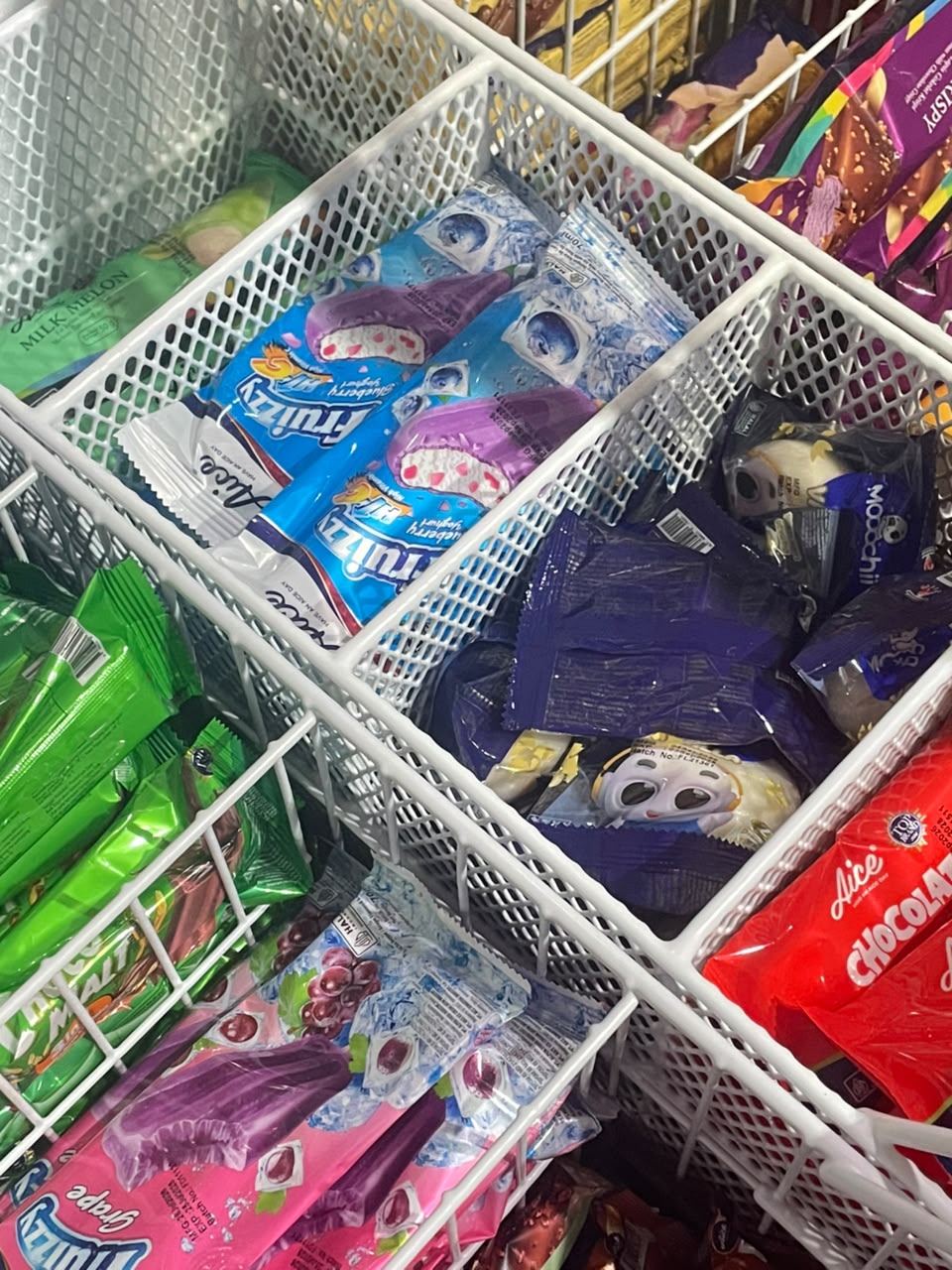 Aneka es krim kemasan di dalam keranjang freezer toko