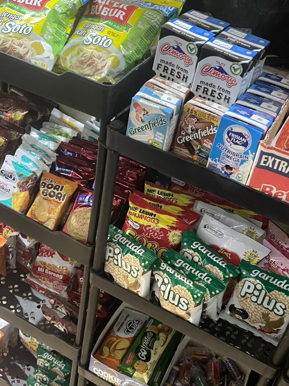 Rak toko berisi camilan kemasan dan susu kotak